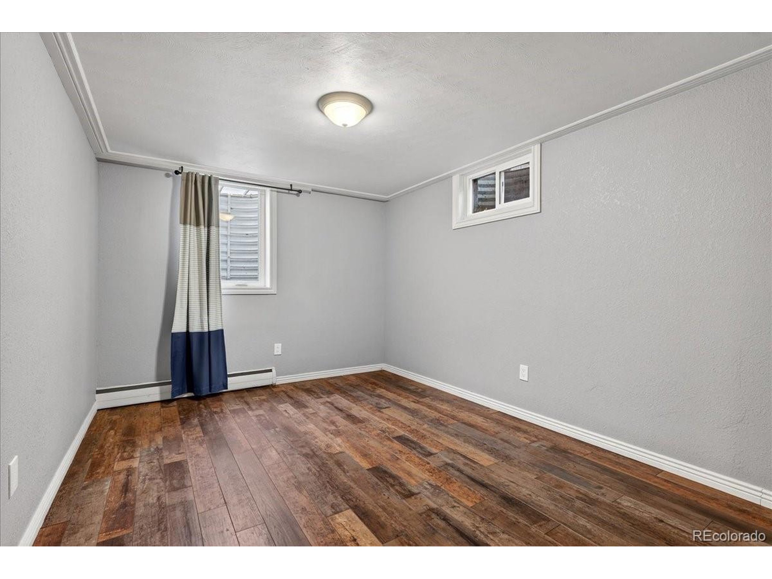 3135 Wright Court Wheat Ridge, CO 80215 - Photo 29 of 50 an empty room with wooden floor and windows