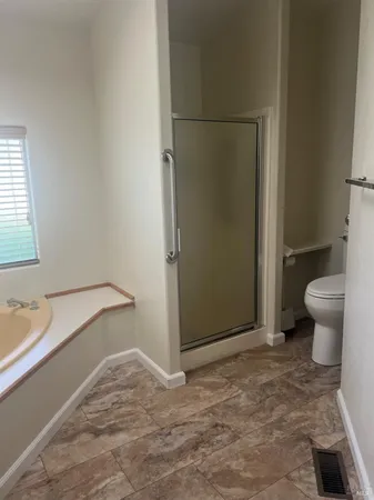 a bathroom with a granite countertop sink and a toilet