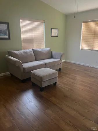 a living room with furniture and a hard wood floor