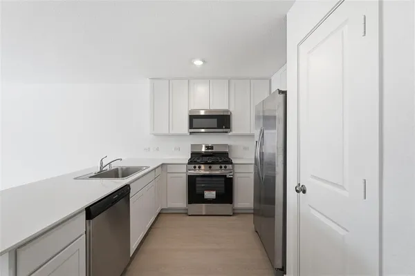 a kitchen with a sink and stainless steel appliances