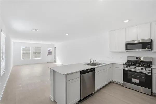 a kitchen with sink a microwave and cabinets