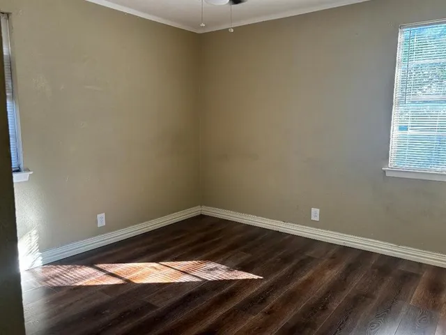 a view of a small space with wooden floor and a window