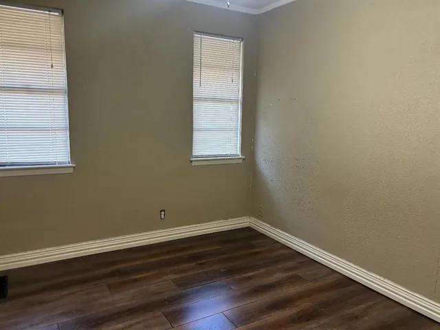 a view of a room with wooden floor and windows