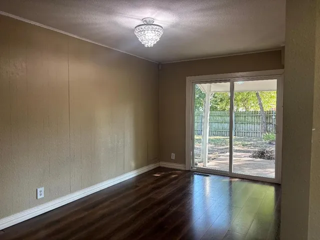 a view of room with hardwood floor and a ceiling fan