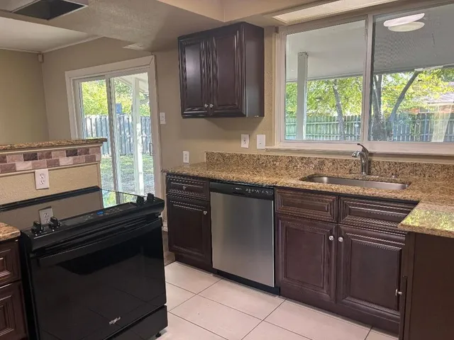 a kitchen with granite countertop a sink and a stove