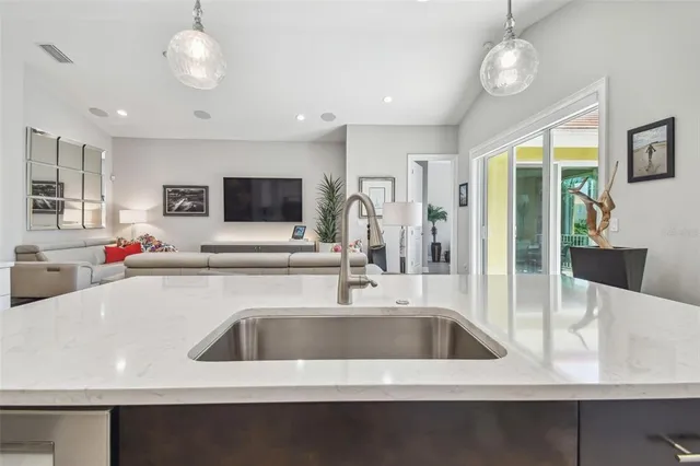 a kitchen with a sink a large window and a clock