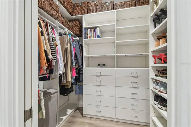 a view of walk in closet with clothes and shoes