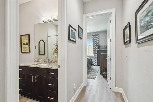 a en suite bathroom with a granite countertop sink vanity and mirror