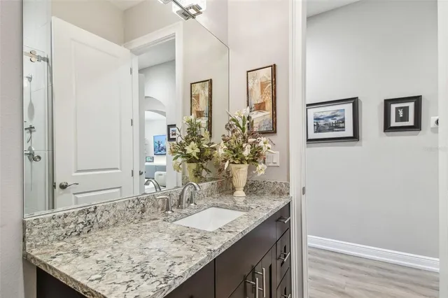 a bathroom with a granite countertop sink and a mirror