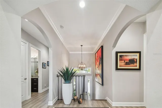 a view of a hallway with wooden floor and table and chairs
