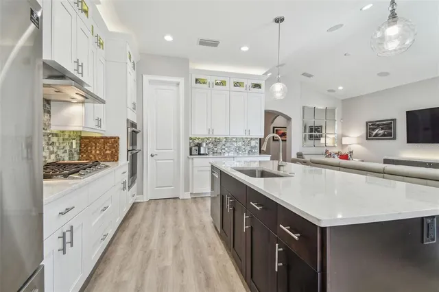 a kitchen with counter top space a sink stainless steel appliances and cabinets