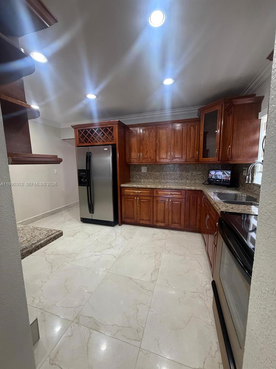 281 West 17th Street, Unit 281 Hialeah, FL 33010 - Photo 4 of 25 a kitchen with stainless steel appliances granite countertop a refrigerator and a stove