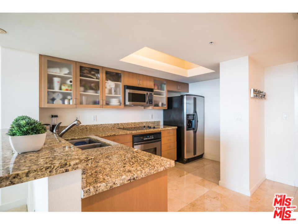13700 Marina Pointe Drive, Unit 1219 Marina del Rey, CA 90292 - Photo 4 of 48 a kitchen with stainless steel appliances granite countertop a refrigerator and a stove top oven