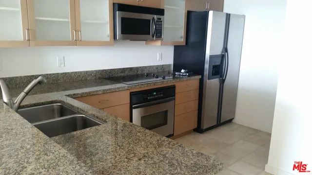a kitchen with granite countertop a sink and a refrigerator