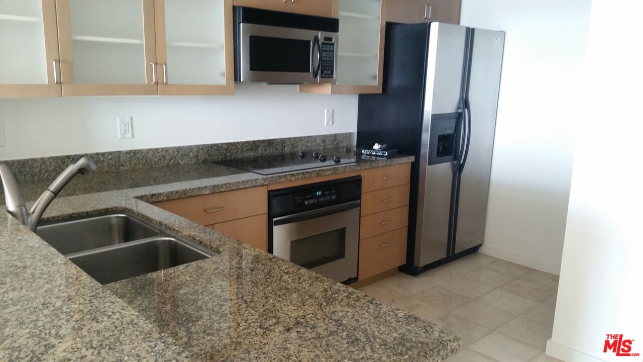 13700 Marina Pointe Drive, Unit 1219 Marina del Rey, CA 90292 - Photo 5 of 48 a kitchen with granite countertop a sink and a refrigerator
