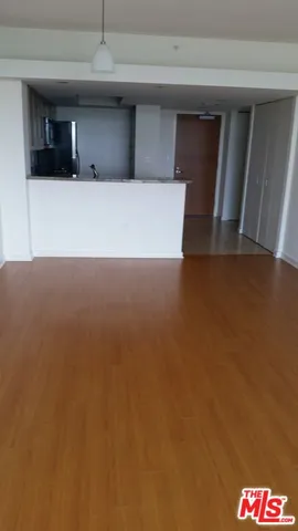a view of a livingroom with wooden floor and a window