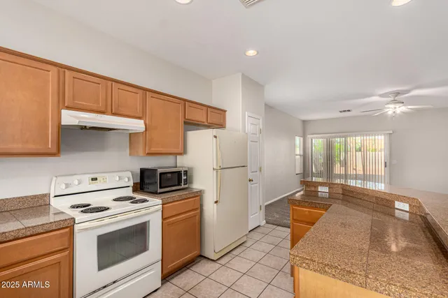 a kitchen with granite countertop a sink stove and refrigerator