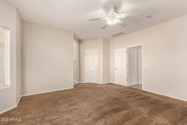 a view of a room with a ceiling fan and a window