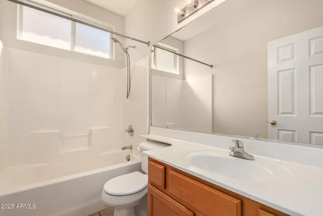 a bathroom with a granite countertop sink a toilet and shower