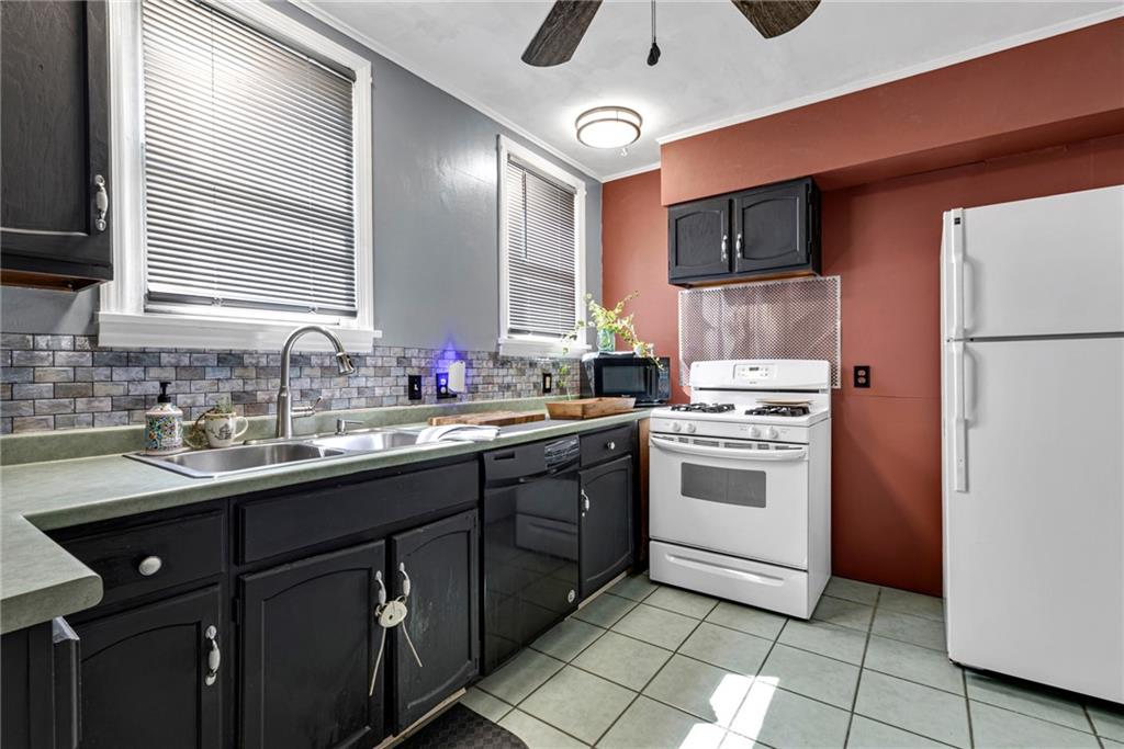 1201 5th Avenue Freedom, PA 15042 - Photo 12 of 32 a kitchen with stainless steel appliances granite countertop a sink a stove a refrigerator cabinets and a dining table