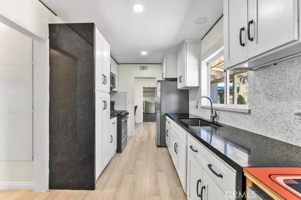 a large kitchen with granite countertop a lot of counter space and stainless steel appliances