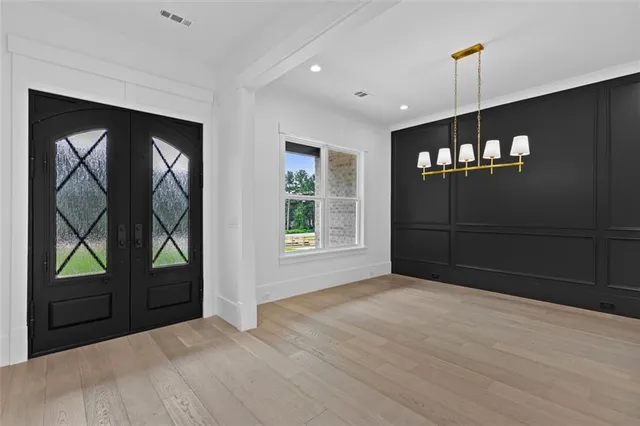 an empty room with wooden floor ceiling fan and windows
