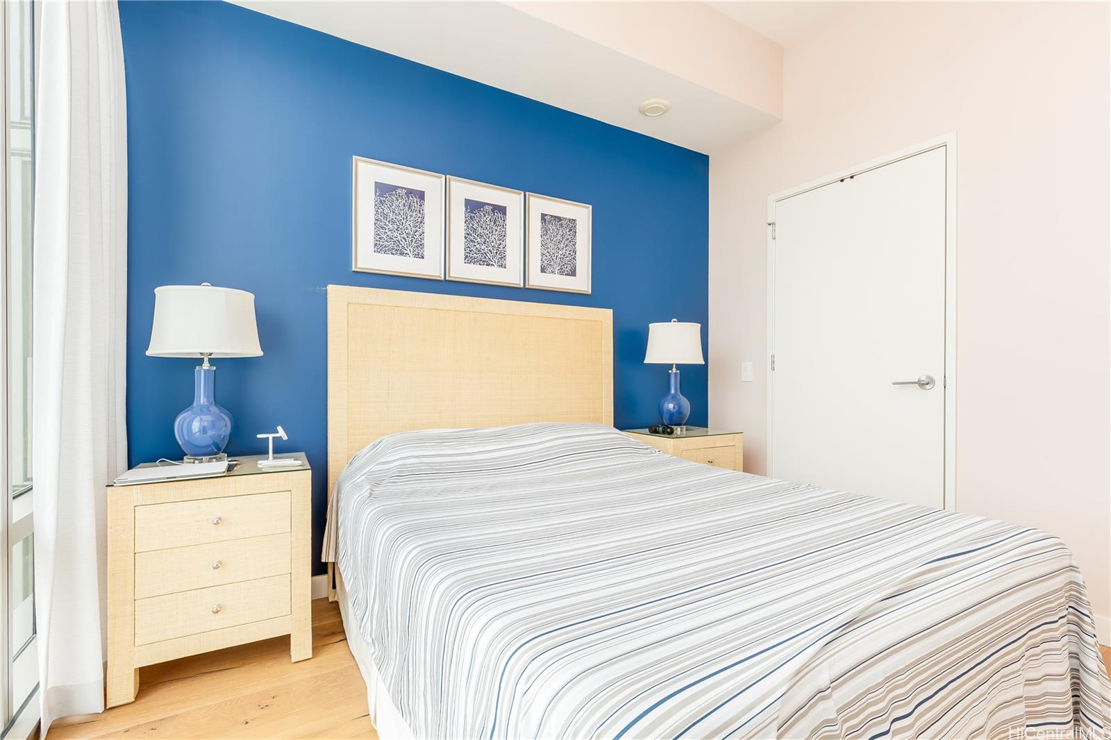 1001 Queen Street, Unit 3907 Honolulu, HI 96814 - Photo 2 of 25 a bedroom with a bed and a lamp on dresser