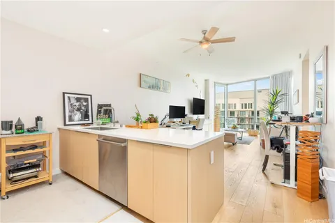a living room with stainless steel appliances kitchen island furniture and a table