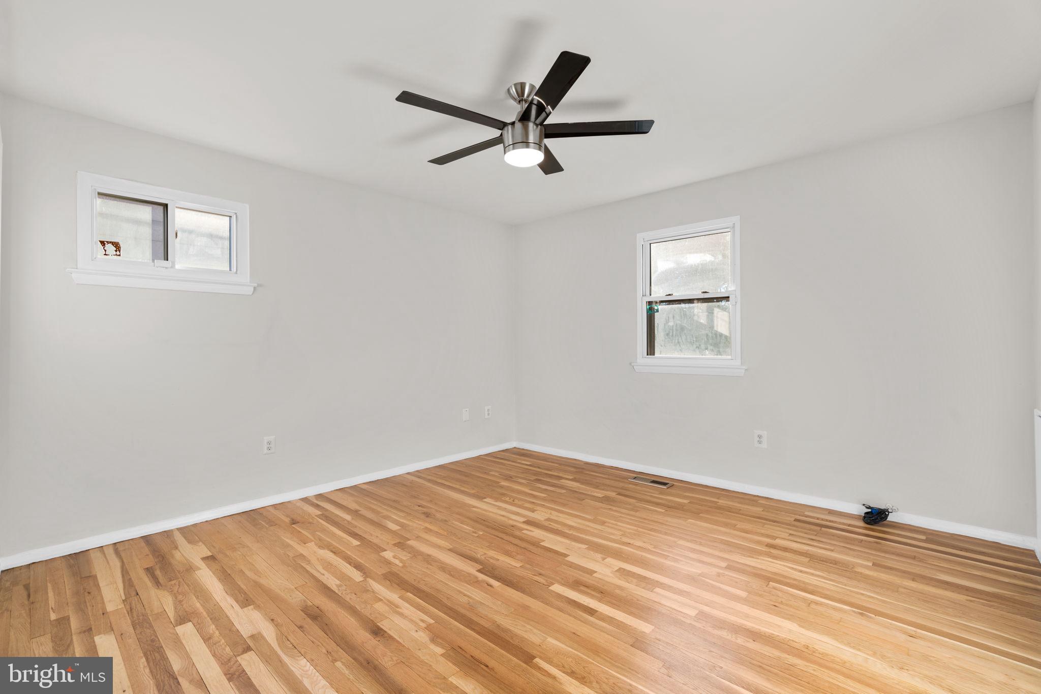 8111 Phirne Road East Glen Burnie, MD 21061 - Photo 14 of 30 a view of empty room with wooden floor and ceiling fan