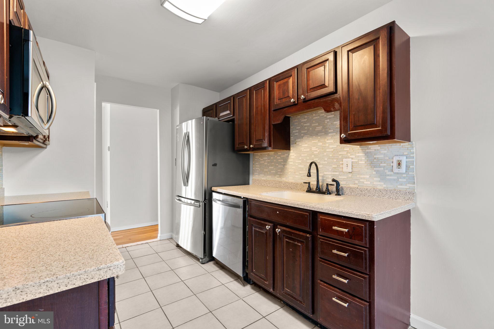 8111 Phirne Road East Glen Burnie, MD 21061 - Photo 8 of 30 a kitchen with a sink refrigerator and cabinets