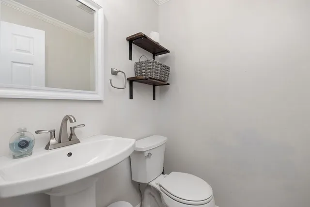 a bathroom with a toilet a sink and mirror