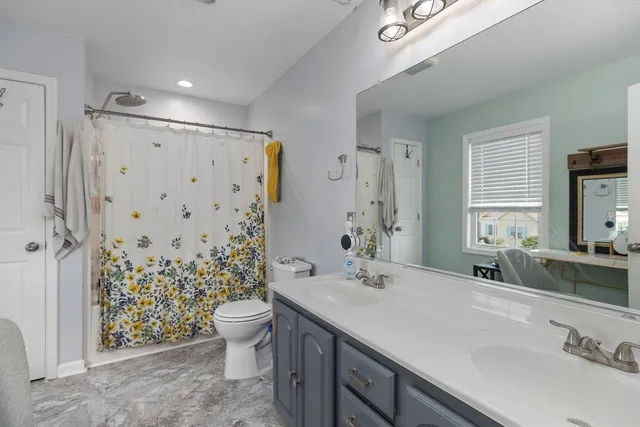 a bathroom with a double vanity sink toilet and shower