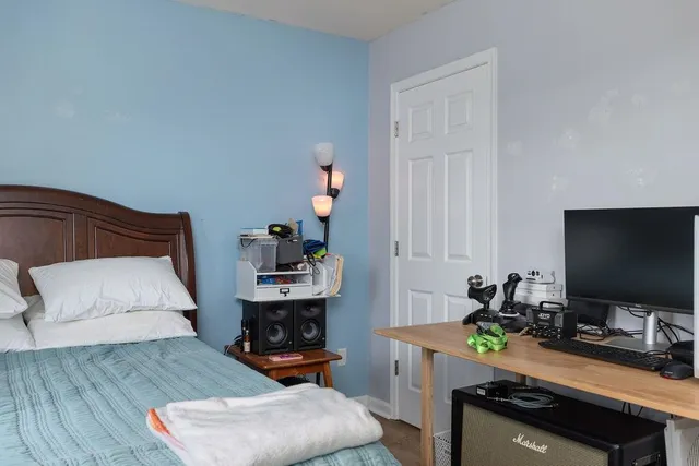 a bedroom with a bed and a flat screen tv