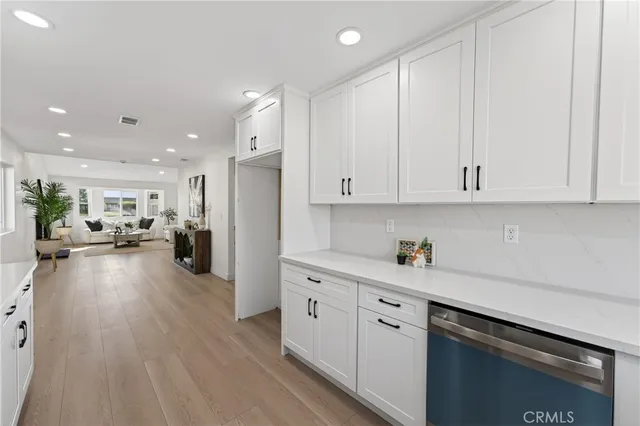 a kitchen with white cabinets and stainless steel appliances