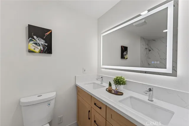 a bathroom with a sink a toilet and mirror