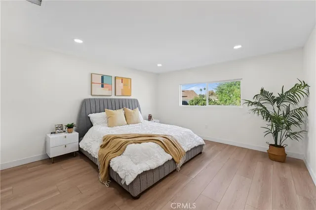 a bedroom with bed and a potted plant
