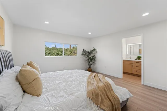 a bedroom with a large bed and a potted plant