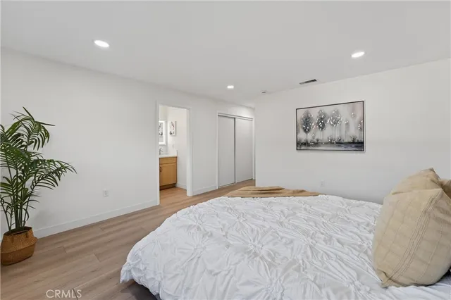 a bedroom with a large bed and a potted plant