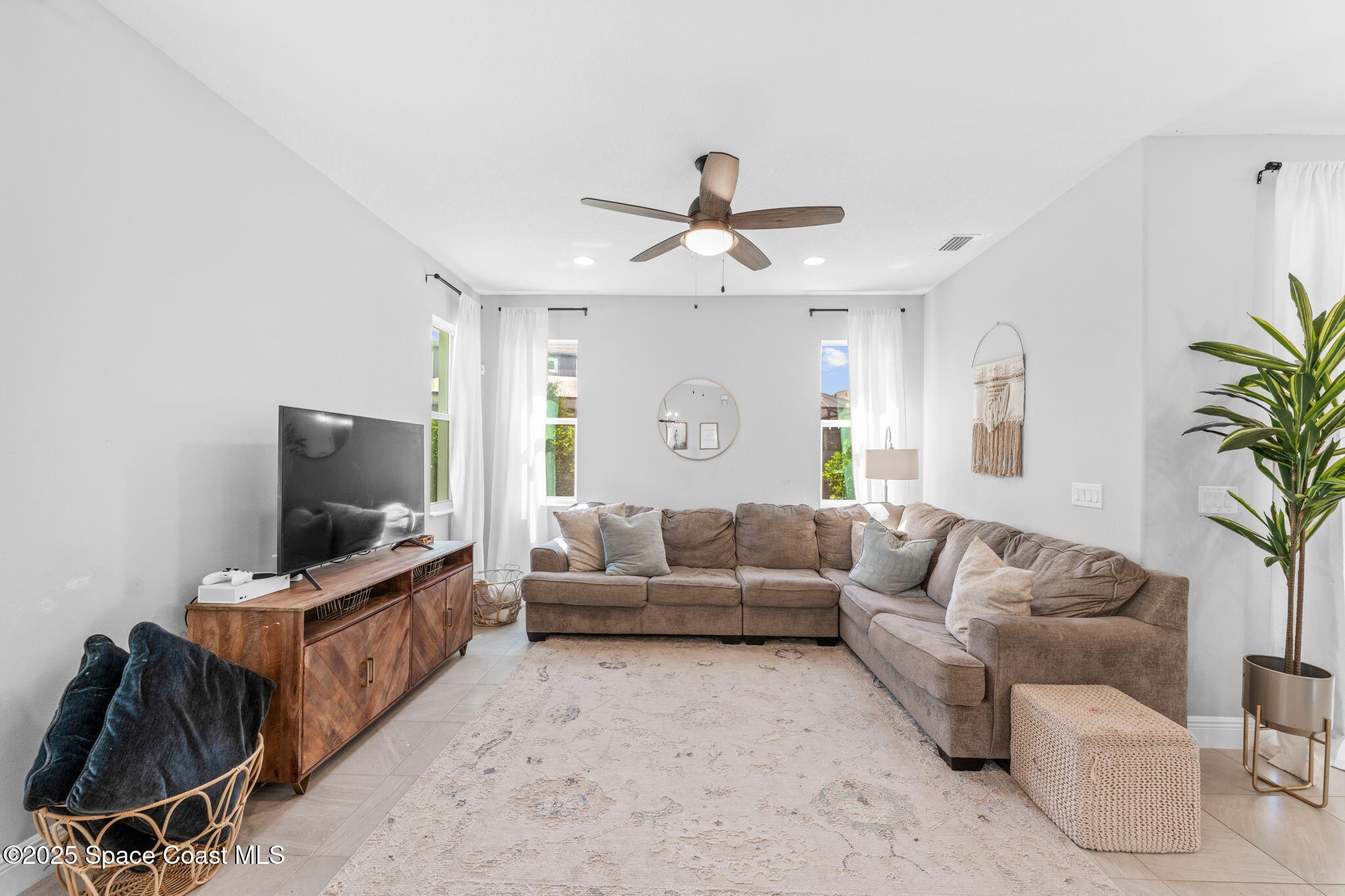 3089 Ribbon Grass Drive Melbourne, FL 32940 - Photo 16 of 57 a living room with furniture and a flat screen tv