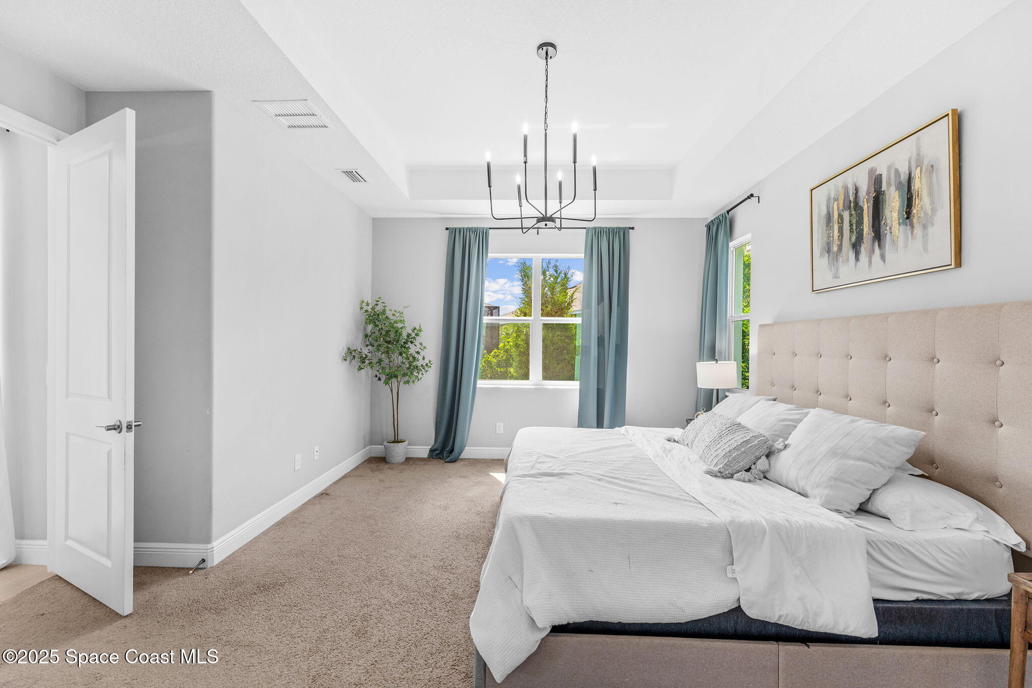 3089 Ribbon Grass Drive Melbourne, FL 32940 - Photo 19 of 57 a bedroom with a bed and a chandelier