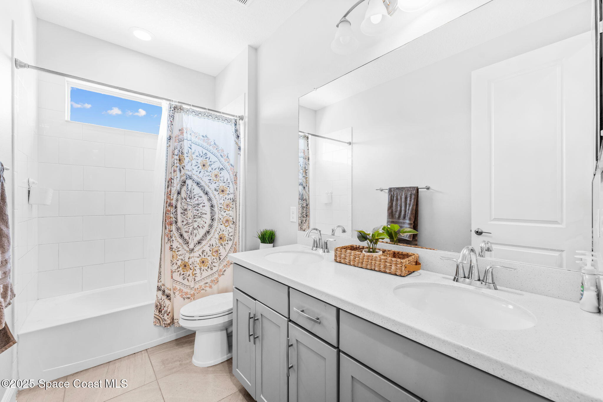 3089 Ribbon Grass Drive Melbourne, FL 32940 - Photo 33 of 57 a bathroom with double vanity sink a toilet a mirror and shower