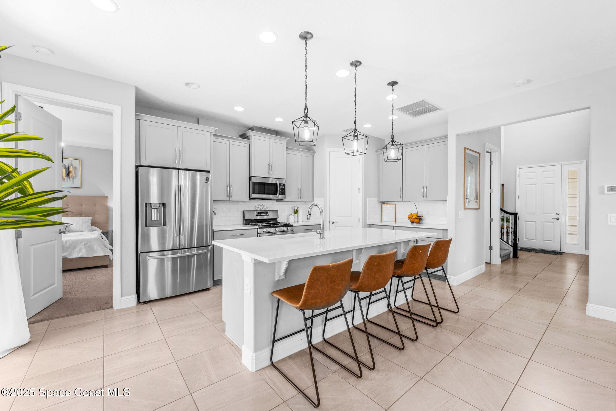 3089 Ribbon Grass Drive Melbourne, FL 32940 - Photo 6 of 57 a kitchen with refrigerator and chairs