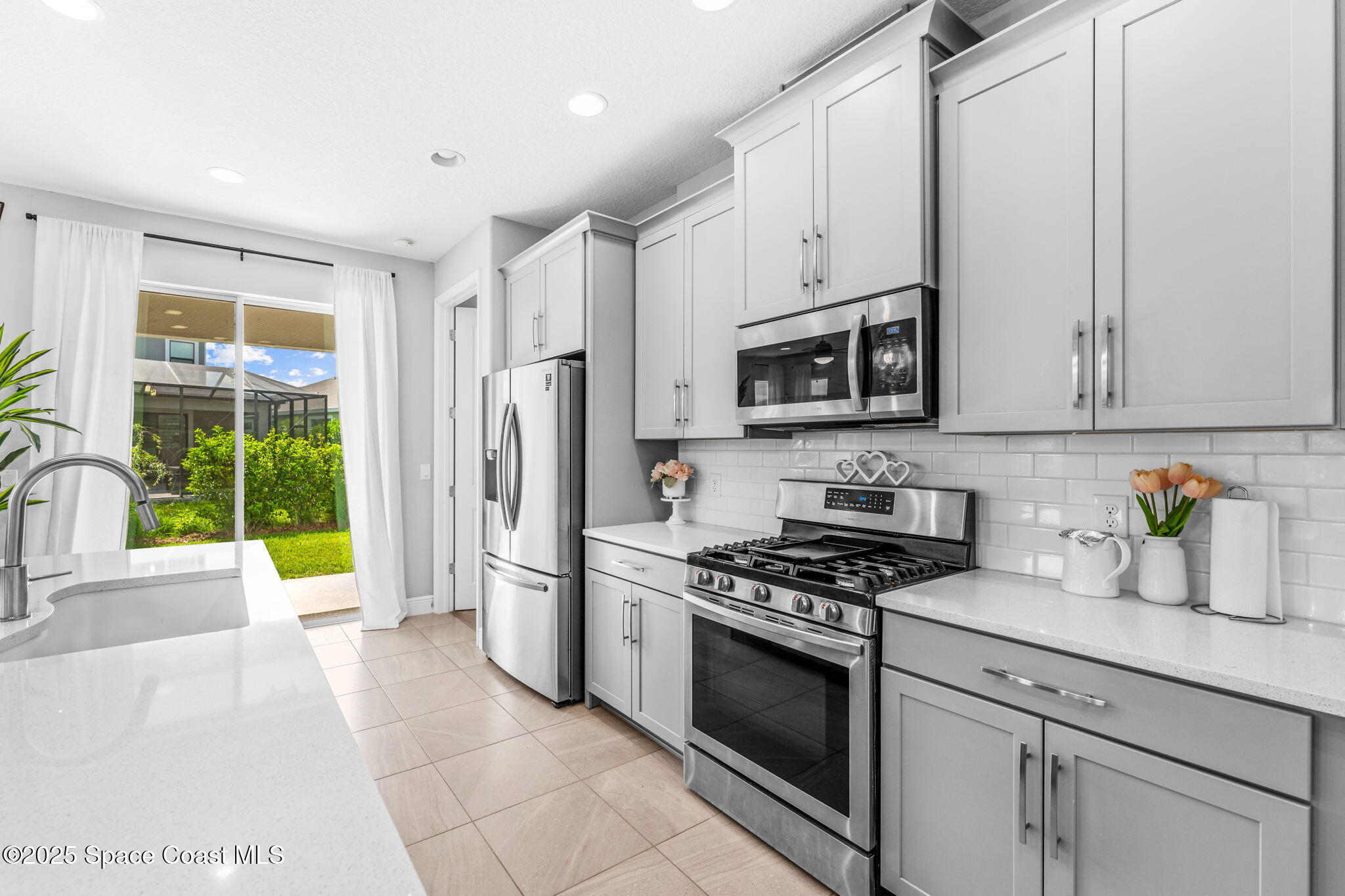 3089 Ribbon Grass Drive Melbourne, FL 32940 - Photo 9 of 57 a kitchen with stainless steel appliances white cabinets and a stove top oven
