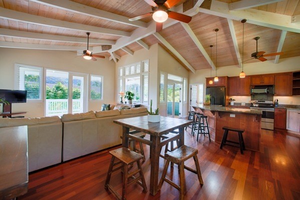 4451 Mahimahi Road Hanalei, HI 96714 - Photo 6 of 25 a kitchen with stainless steel appliances granite countertop a stove a refrigerator a dining table and chairs with wooden floor