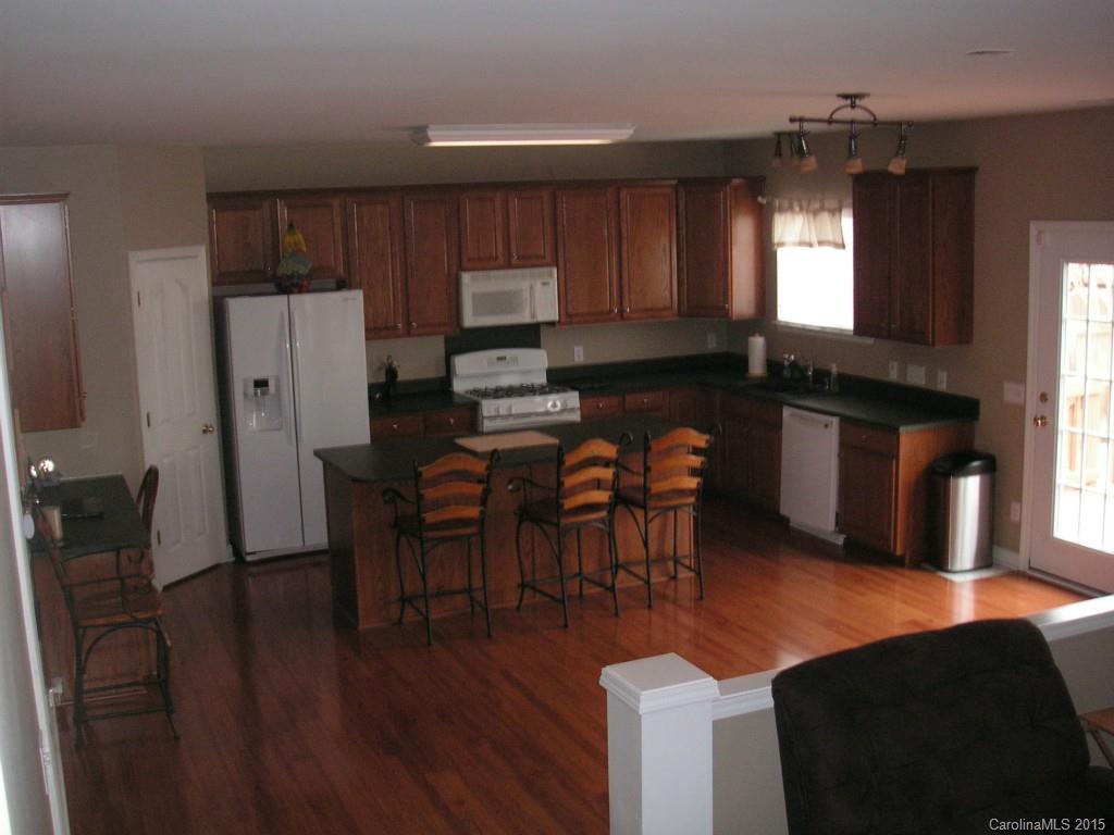 312 Altovista Court Fort Mill, SC 29708 - Photo 5 of 24 a kitchen with stainless steel appliances wooden floors and wooden cabinets