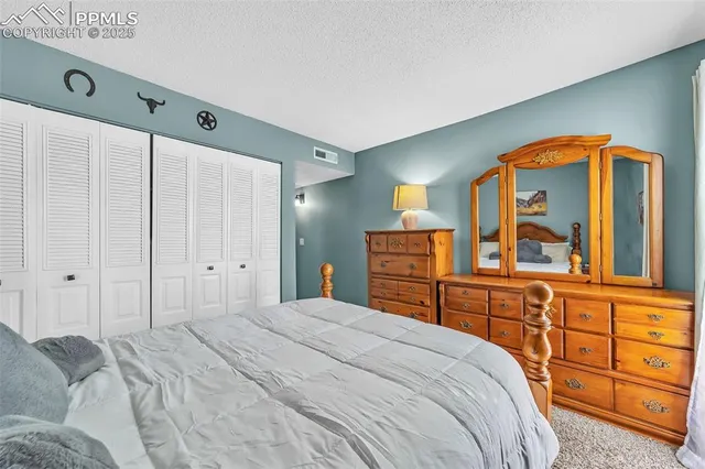 a bedroom with a bed a dresser and mirror
