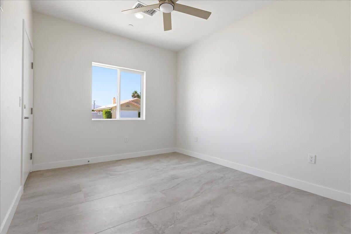 68160 Modalo Road Cathedral City, CA 92234 - Photo 26 of 57 an empty room with a chandelier fan and windows
