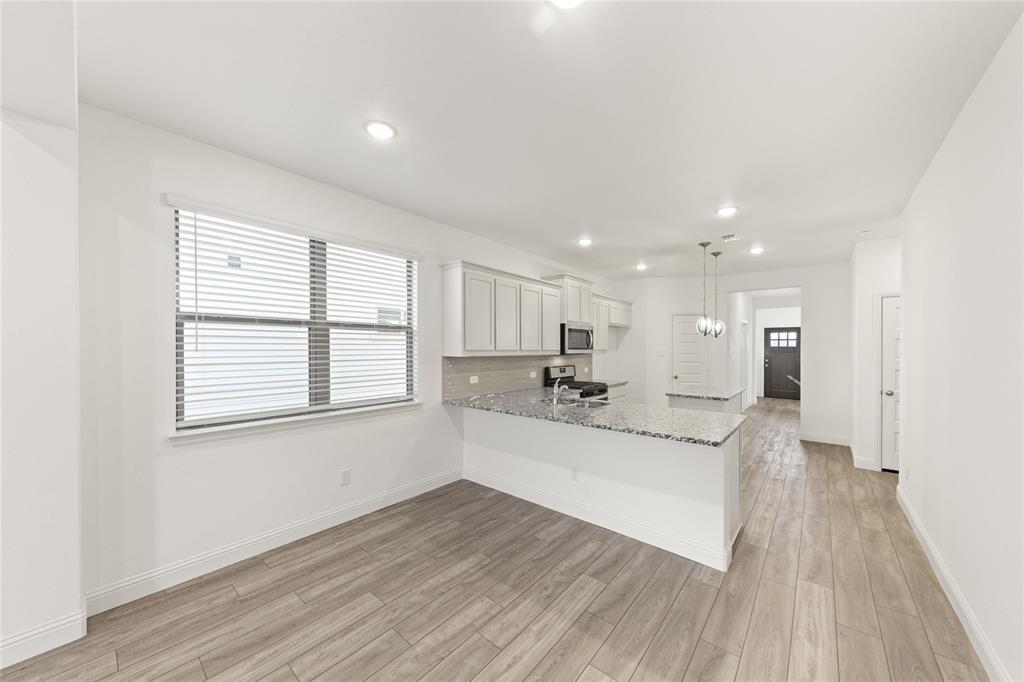 a large white kitchen with kitchen island a stove a sink and a refrigerator