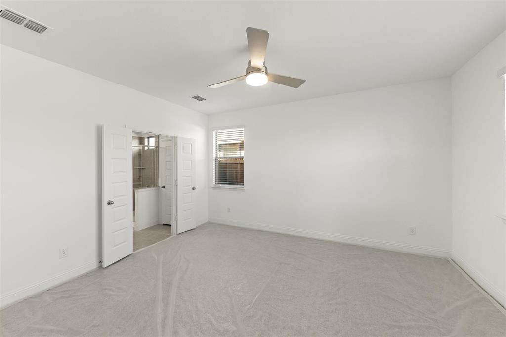 322 Boston Drive Princeton, TX 75407 - Photo 11 of 18 an empty room with chandelier fan and windows