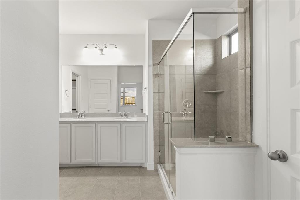 322 Boston Drive Princeton, TX 75407 - Photo 12 of 18 a bathroom with a sink a mirror and a shower